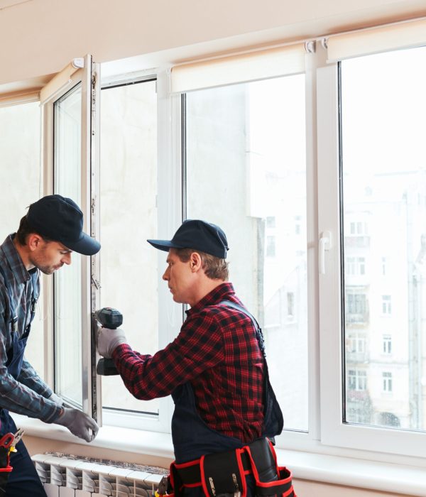 Quality light. Construction workers installing new window in house together